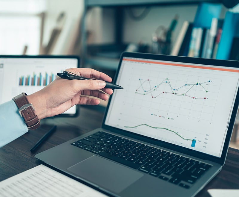 hand pointing at data on laptop