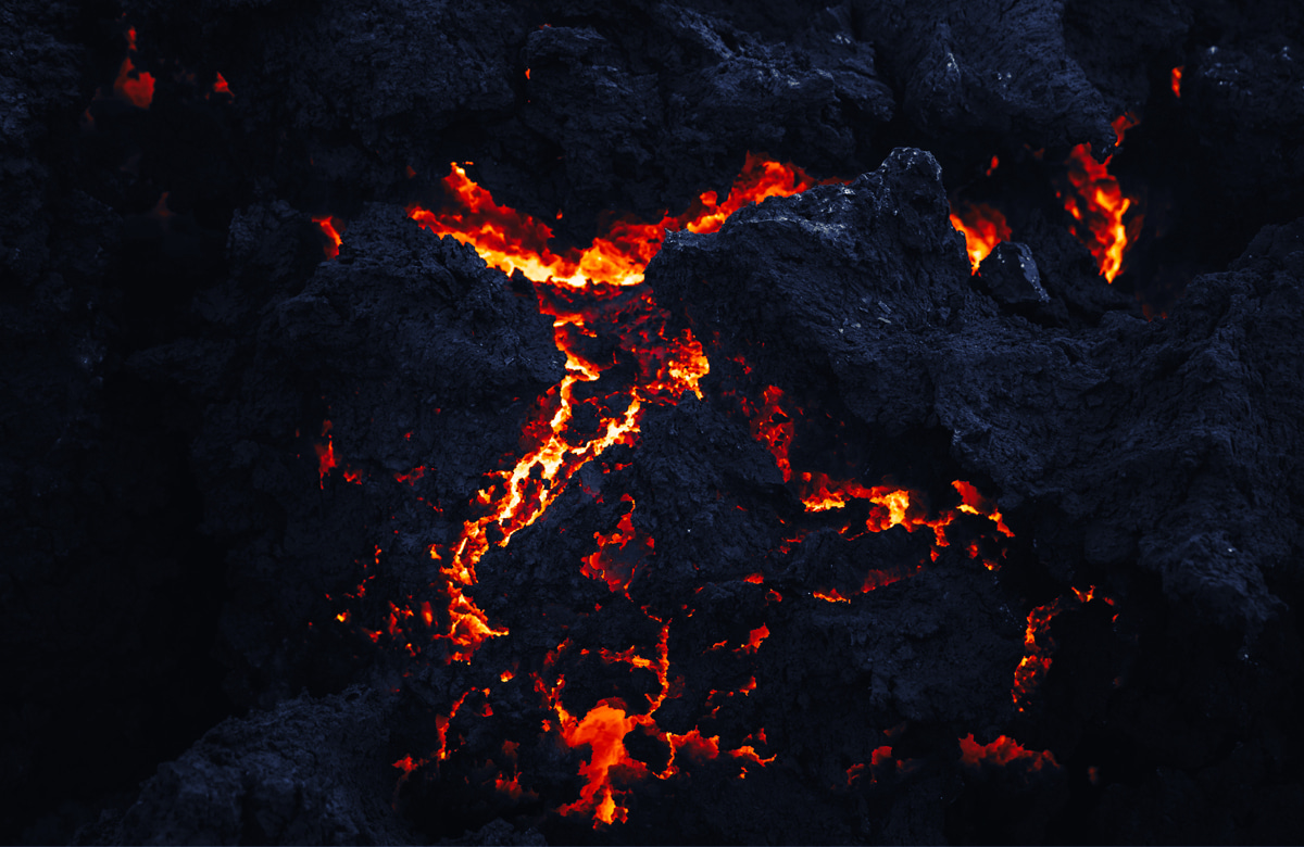 close-up view of molten lava flowing between solidified volcanic rock