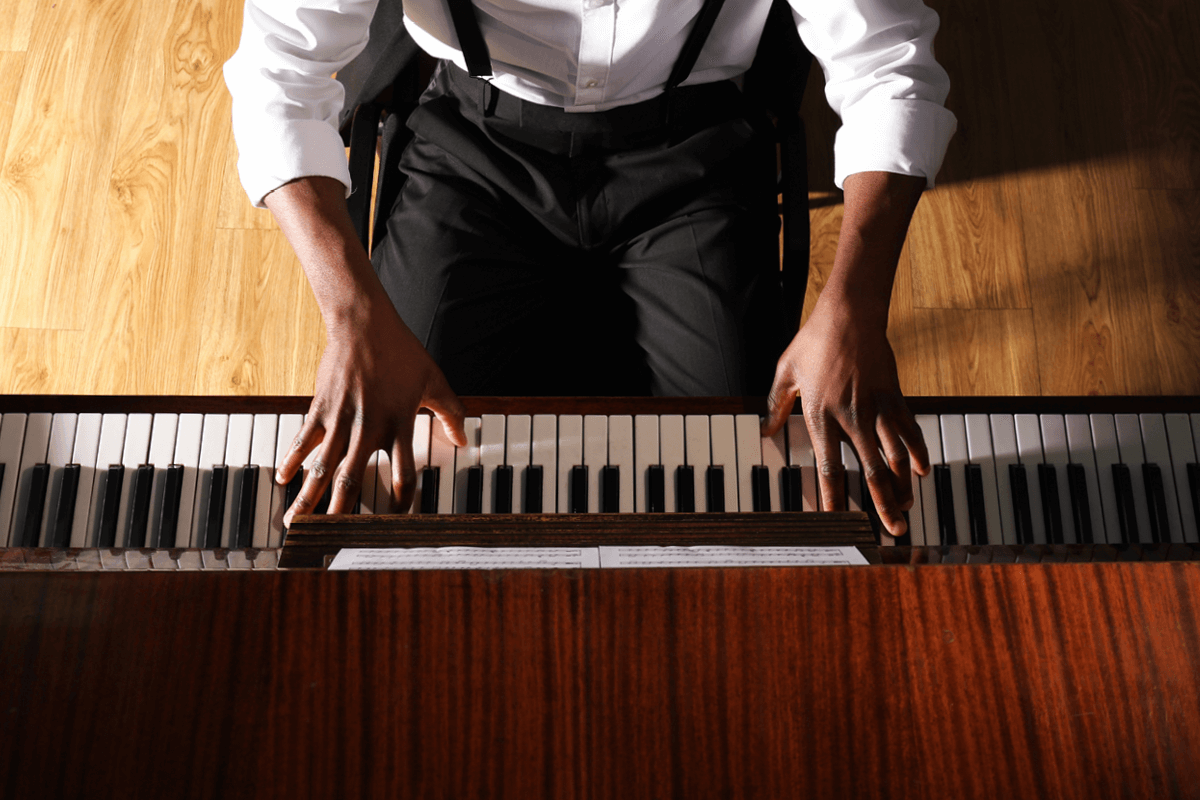 view from above of someone seated on a piano bench playing music