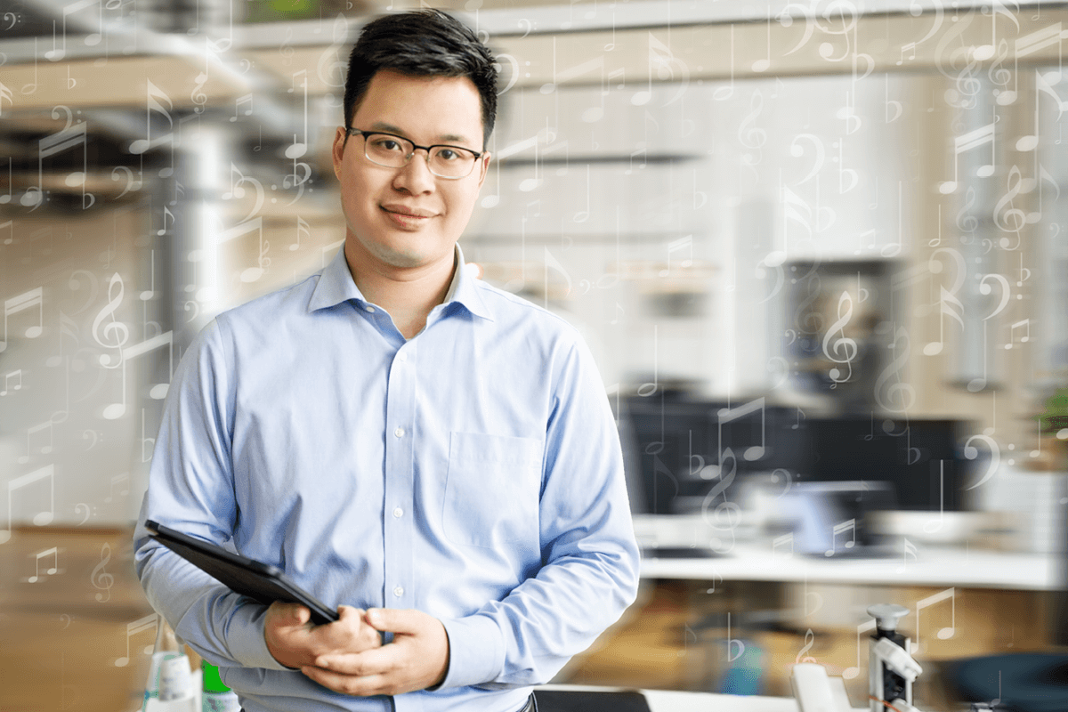Business professional holding a table smiling at camera. White music notes overlay