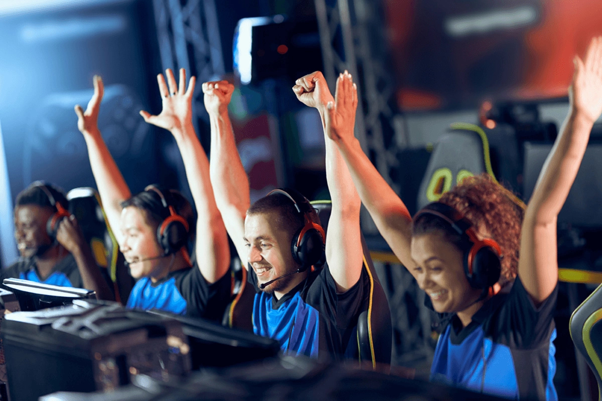 gaming team in matching shirts and headsets celebrating a win