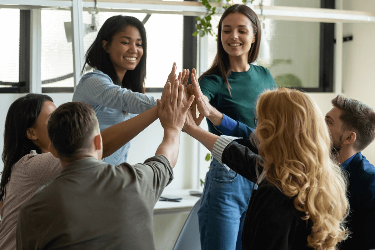 group of men and women high-fiving at the office
