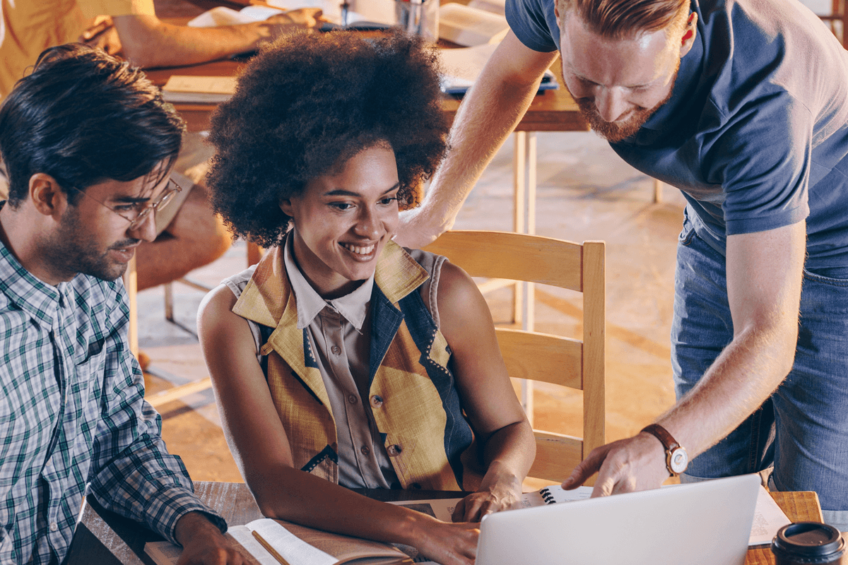 african american woman showing two male colleagues work on her laptop