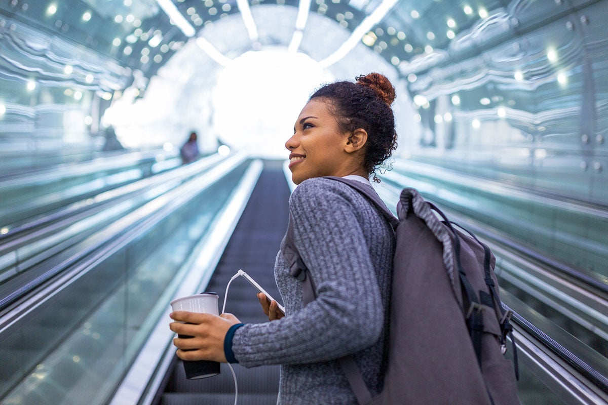woman on escalator looking over her shoulder and smiling