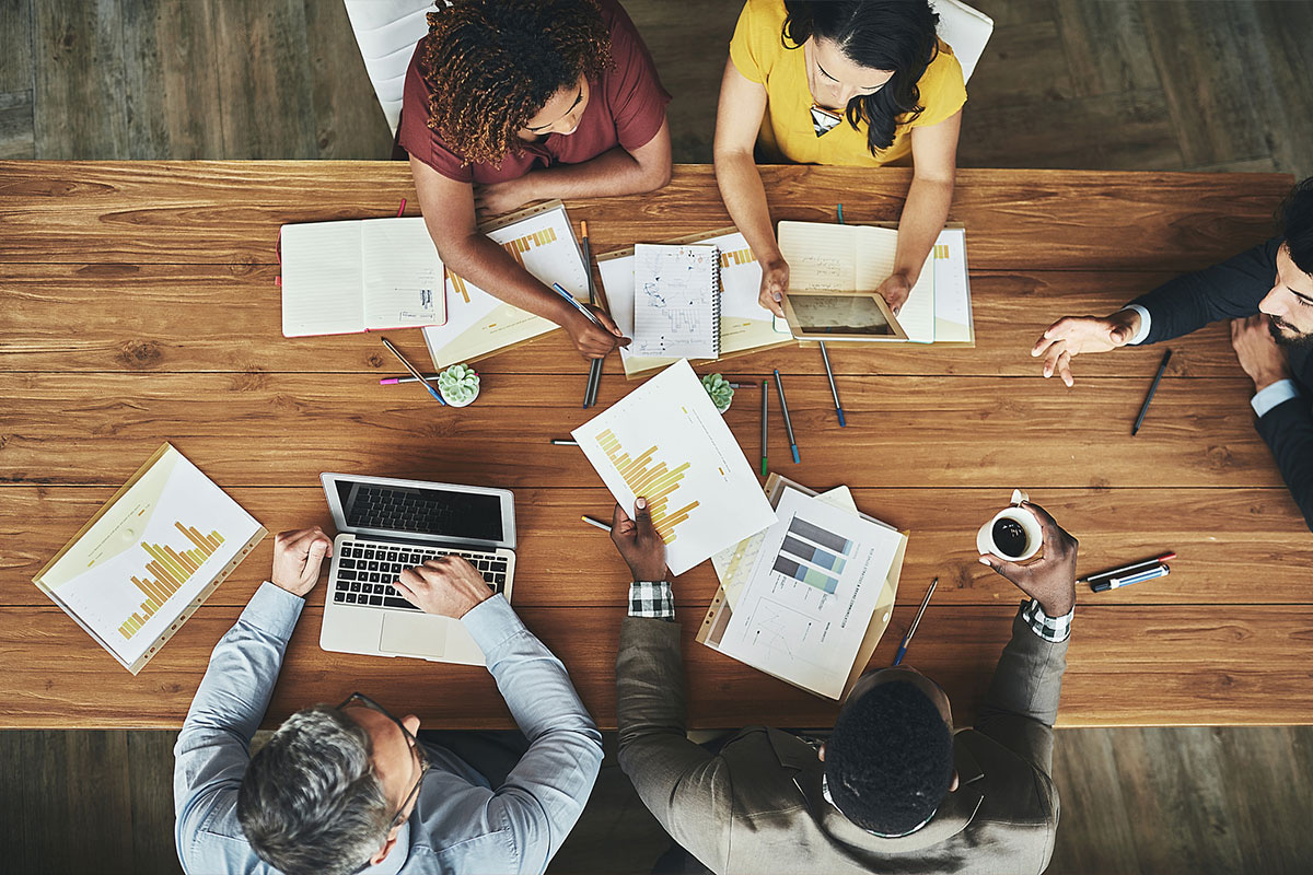 people working at a table with data and papers