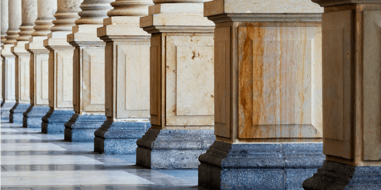 columns from a public sector building during sunrise