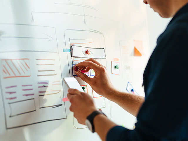 Person at whiteboard designing enterprise applications platform interfaces