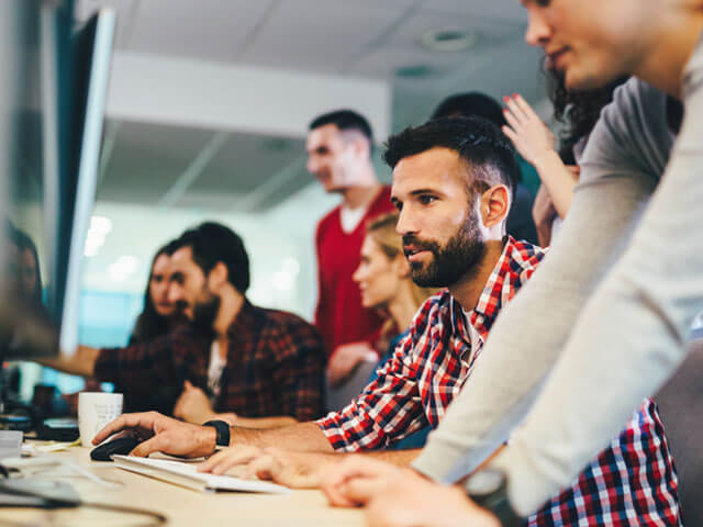 Multiple people at computers discussing ERP deployment and support