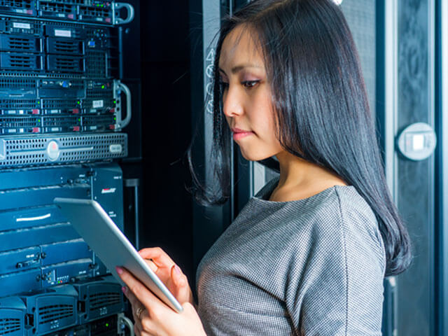 Woman in charge of IoT security standing in front of a server