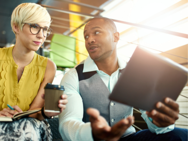 two young professionals reviewing cloud services on tablet
