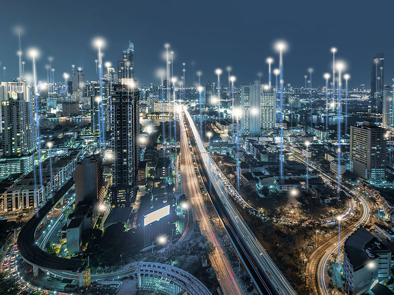 City with beams of of light connecting workplace technology from building to building