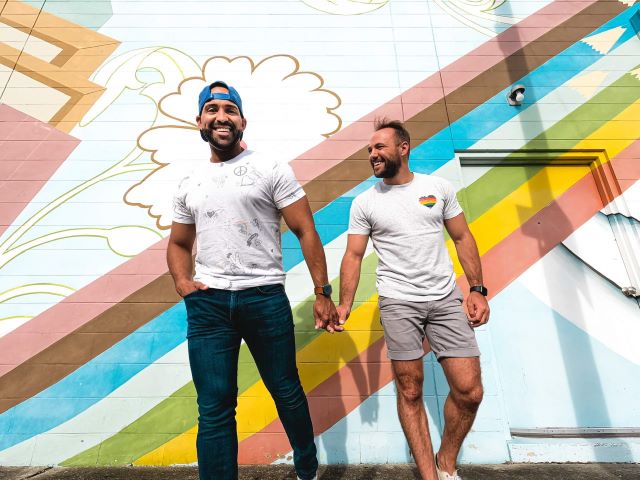 TEKsystems' employee, Alex Seniguar, and his current partner hold hands during a pride event in 2021