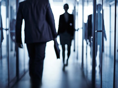 business professionals walk down modern hall