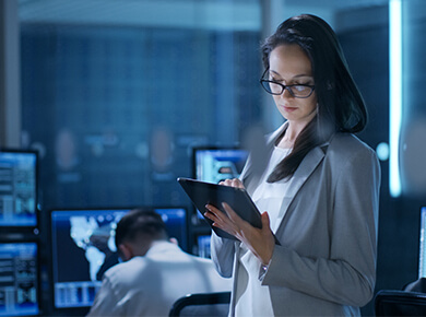 Young Female Engineer Uses Tablet in System Control Center.
