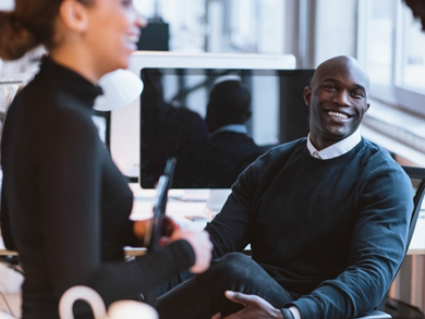 a pair of diverse employees laugh