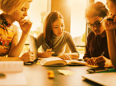 four people looking at a book