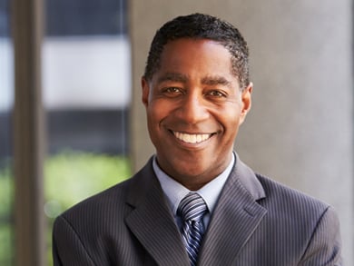 executive man smiles in a gray suit