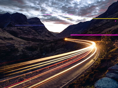 mountain road with neon lights representing digital data speed