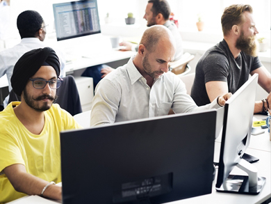 group of modern, diverse help desk workers at computers