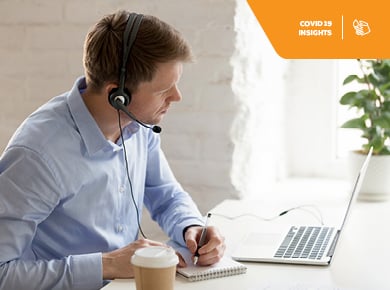 young business professional with wearing headset, taking notes during a virtual interview