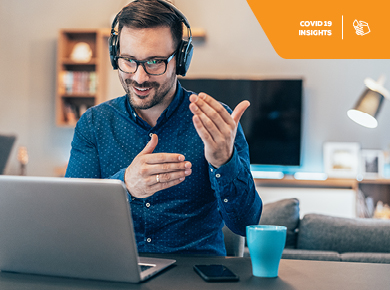 Man working on a laptoop from home with using a headset
