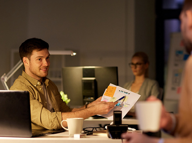 three IT professionals reviewing training manuals and data graphs