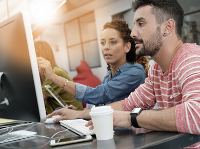 A man and a woman reviewing something on the computer