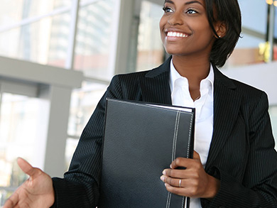 professionally dressed woman reaches for a handshake during an interview
