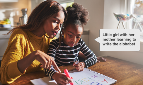 image of little girl with her mother learning to wriate the alphabet with text example of alt text