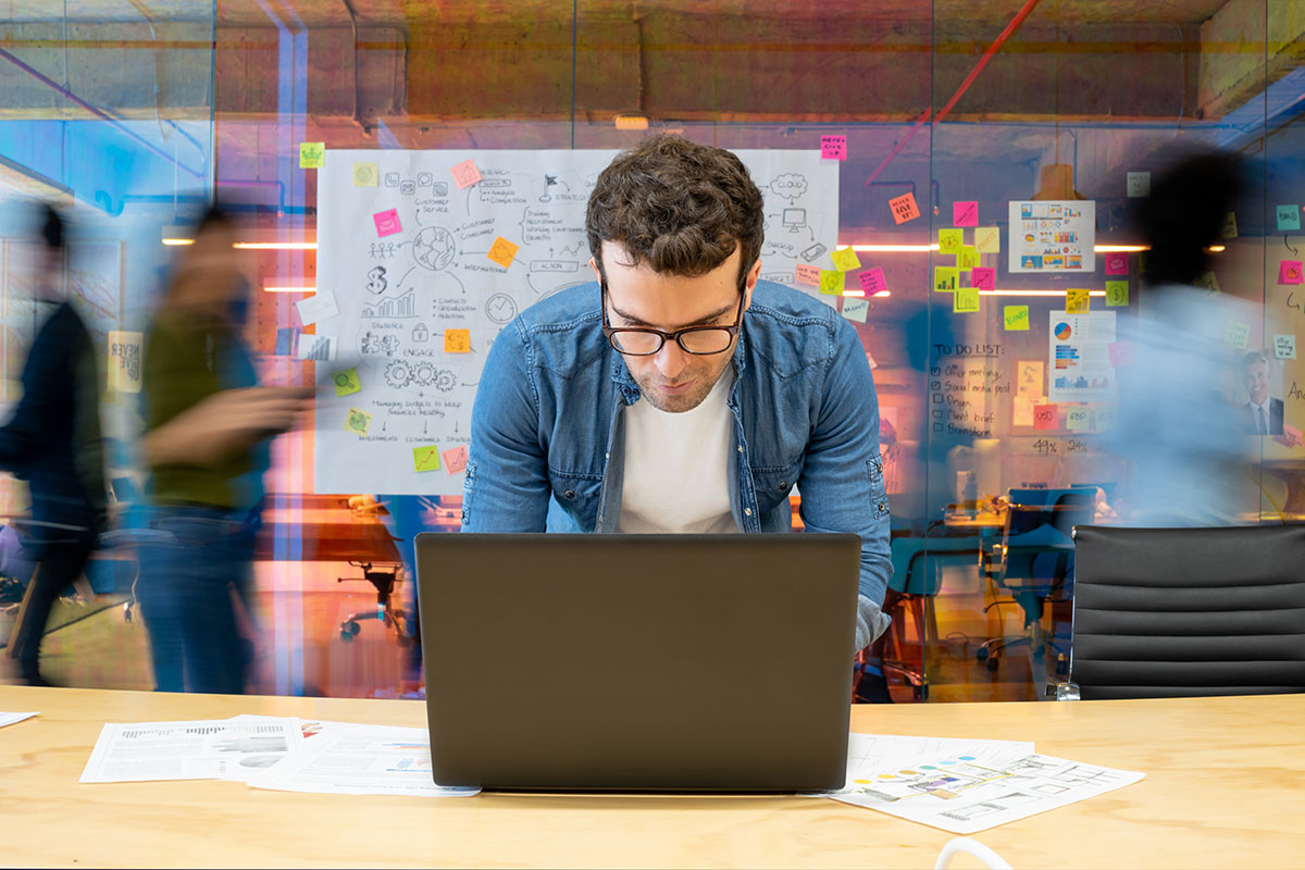 blurred creative office background with man working at laptop in the foreground