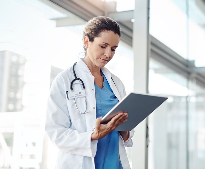 female doctor using digital technology to log patient information