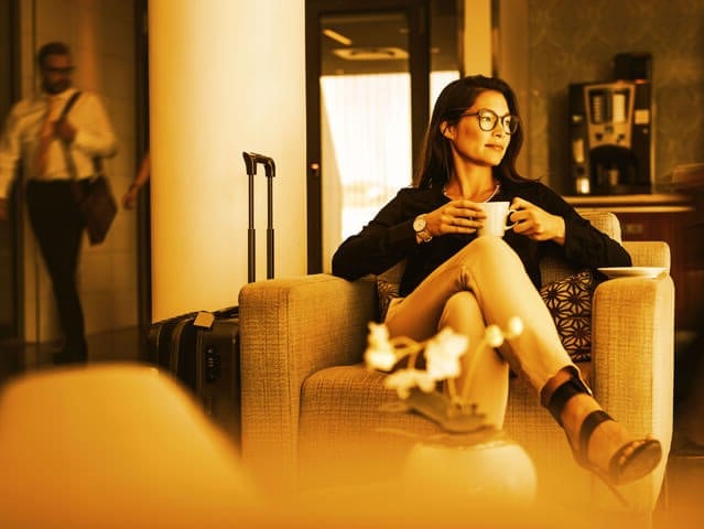 a woman drinking coffee at a hotel