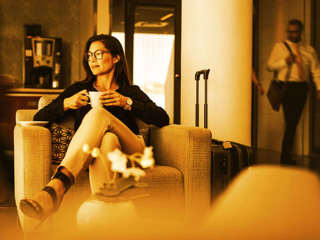 a woman drinking coffee at a hotel