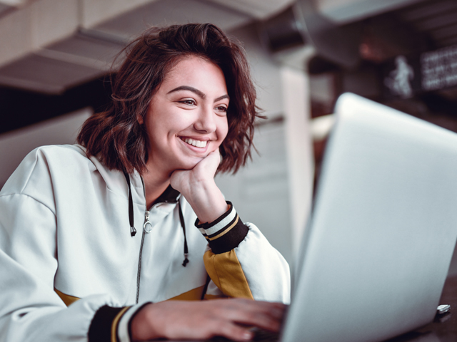 young woman working on a laptop interactiving with the new cloud based system