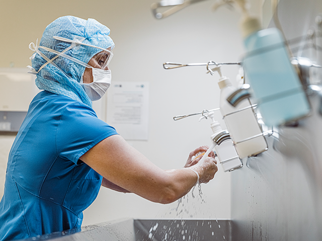 medical professional washing hands in a hospital setting