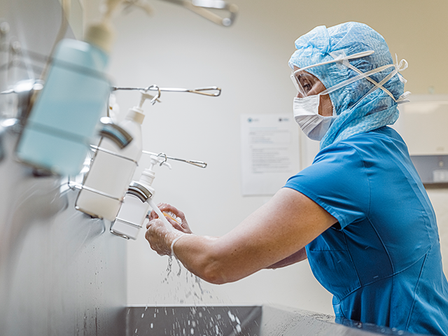 medical professional washing hands in a hospital setting