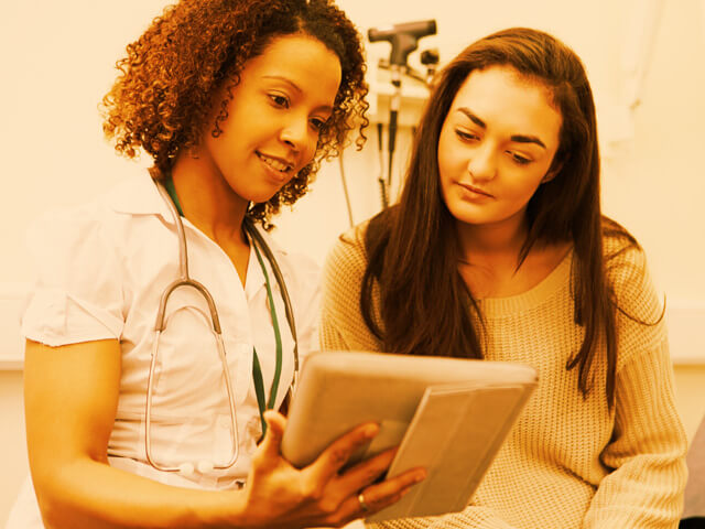 A patient and a nurse reviewing chart information