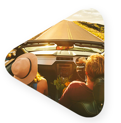 male and female driving the coast in a convertible