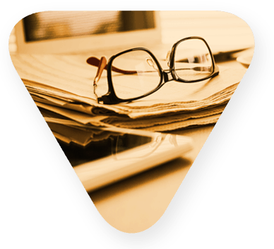 small triangle contains a pair of glasses sitting on papers