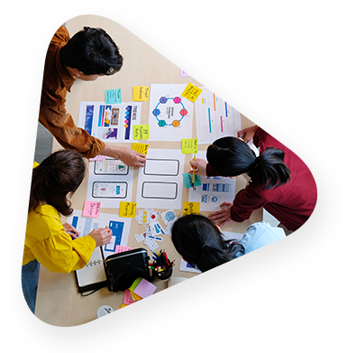 A team working over a conference table plotting out their plans with colored paper